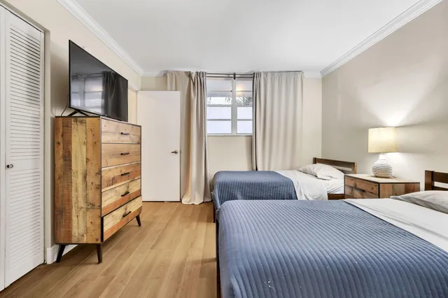 a bedroom with two beds and a night stand