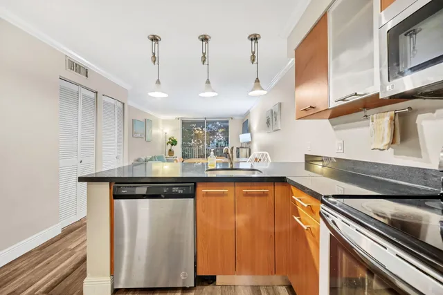 a kitchen with granite countertop a sink a stove a window cabinets and a dining table