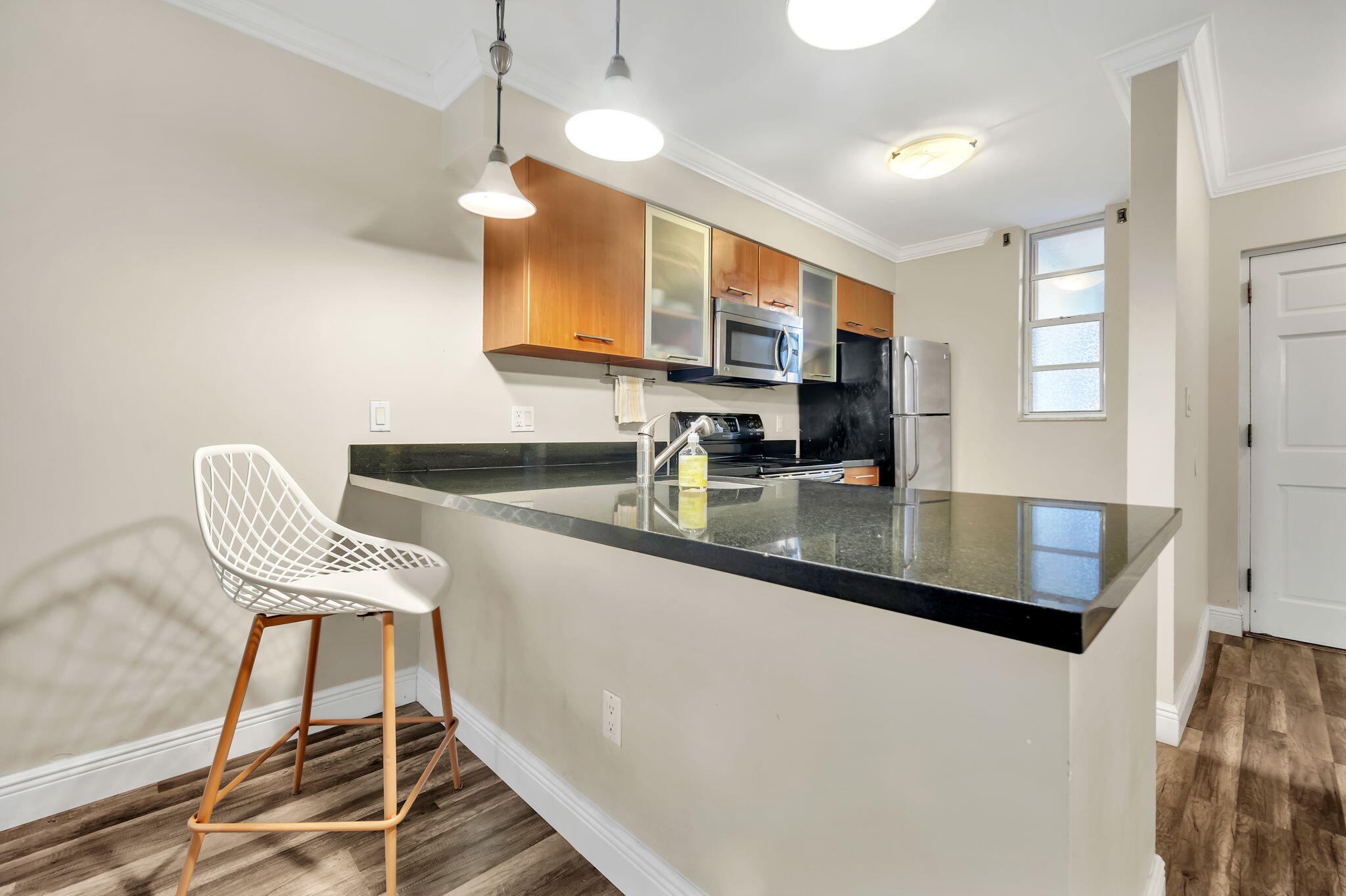 777 Northeast 62nd Street, Unit C512 Miami, FL 33138 - Photo 9 of 40 a kitchen with granite countertop a sink a stove a window cabinets and a dining table