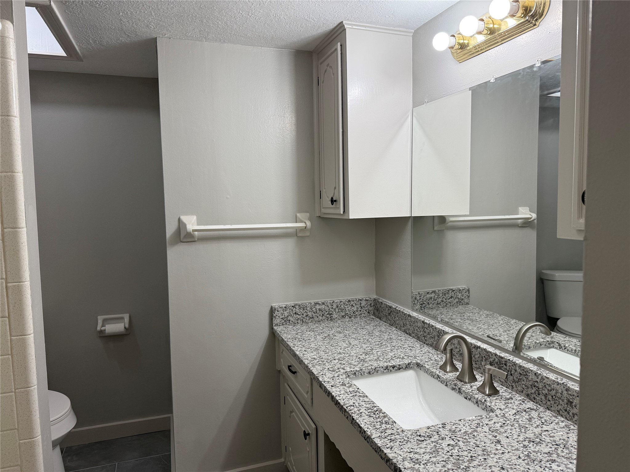 5622 Killough Street Houston, TX 77086 - Photo 16 of 21 a bathroom with a granite countertop sink and a toilet