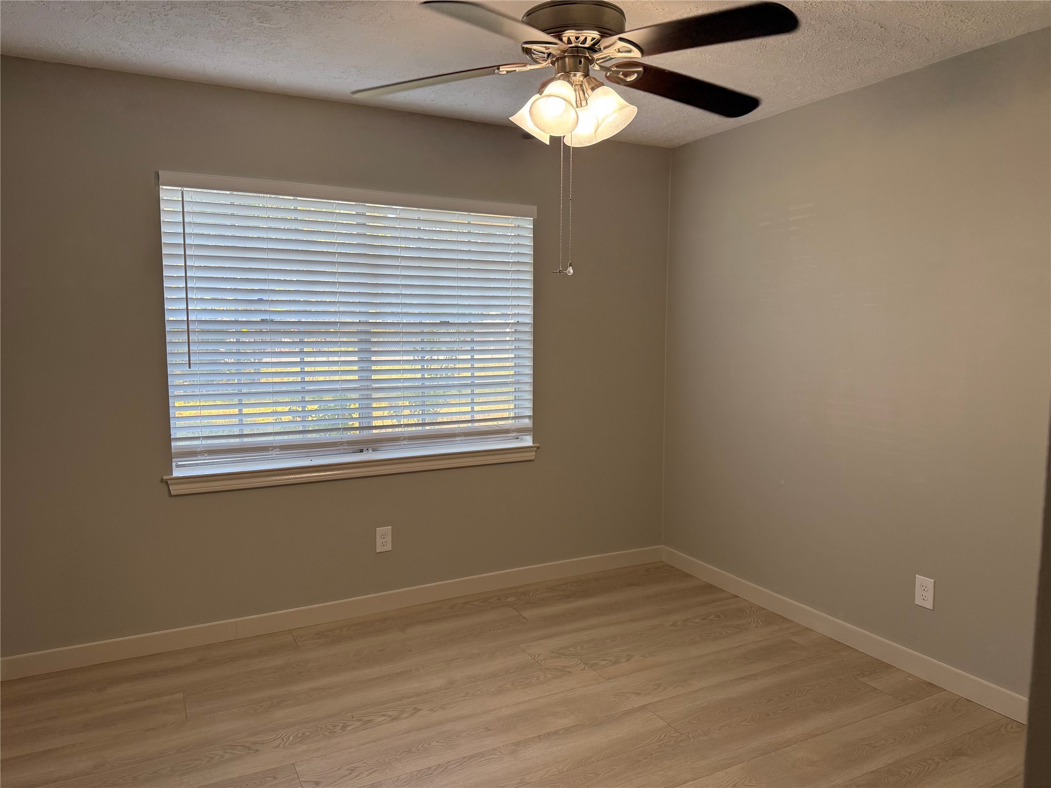 5622 Killough Street Houston, TX 77086 - Photo 18 of 21 an empty room with wooden floor fan and windows