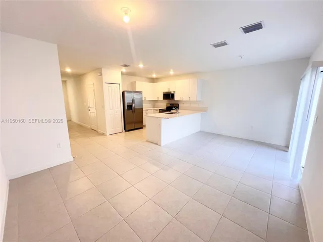 a large kitchen with cabinets and a stainless steel appliances