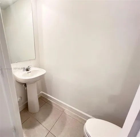 a bathroom with a sink toilet and a mirror