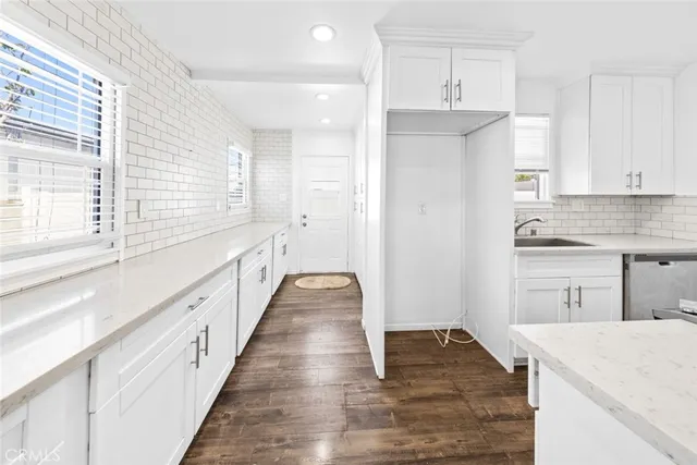 a kitchen with granite countertop white cabinets and white appliances
