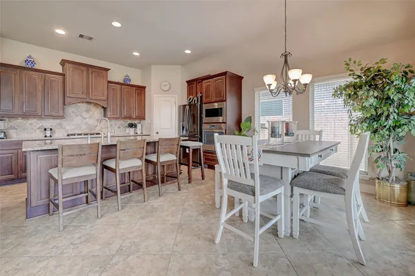 a view of a dining room and livingroom with furniture wooden floor a chandelier