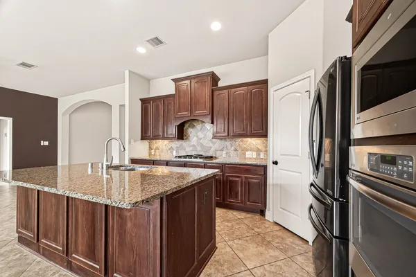 a kitchen with stainless steel appliances granite countertop a sink stove and refrigerator
