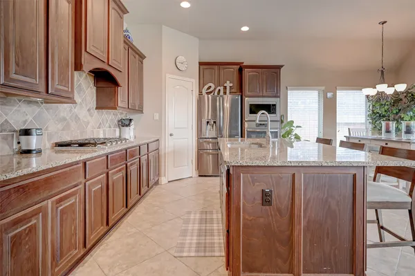 a kitchen with stainless steel appliances granite countertop a refrigerator and a stove top oven