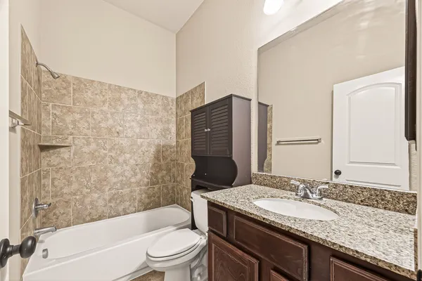 a bathroom with a granite countertop sink toilet and shower
