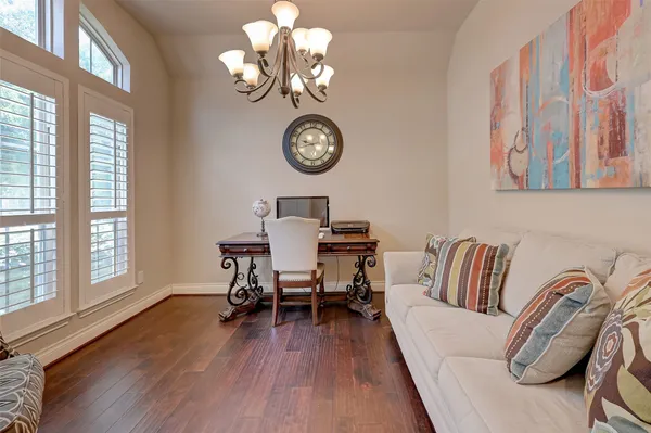 a view of a dining room with furniture a chandelier and wooden floor