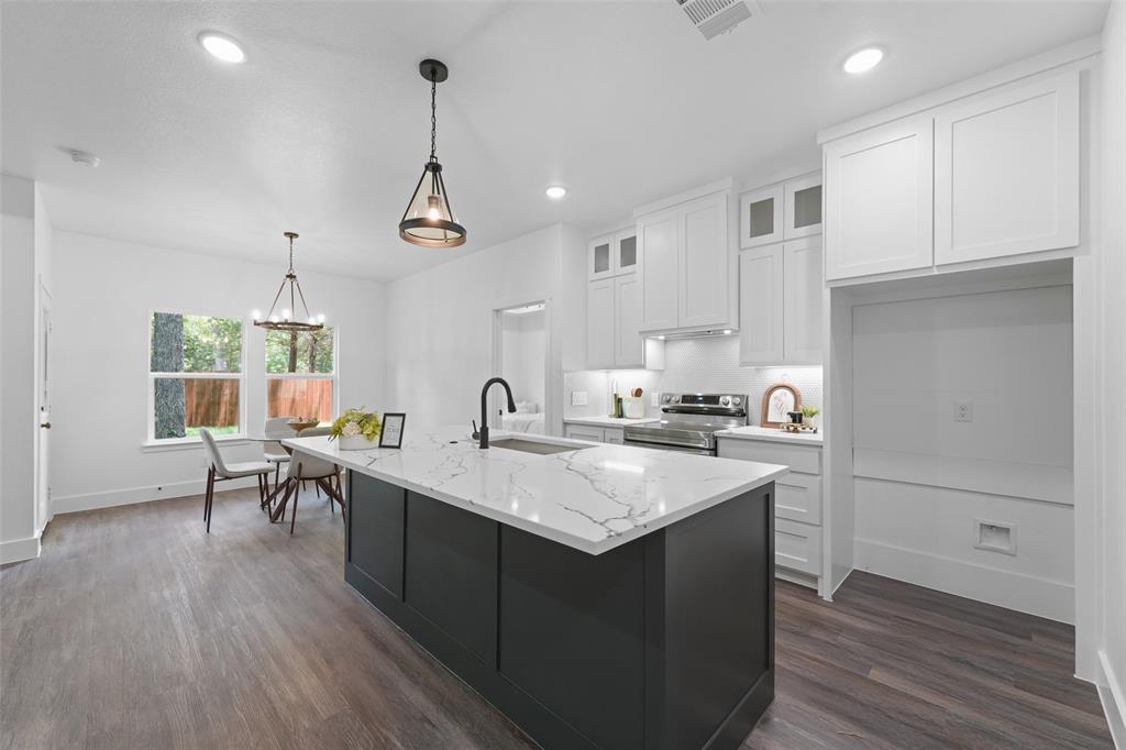 122 East Beachwood Loop Trinidad, TX 75163 - Photo 12 of 35 Kitchen featuring an expansive island with a stone countertop, dark cabinetry, and integrated sink