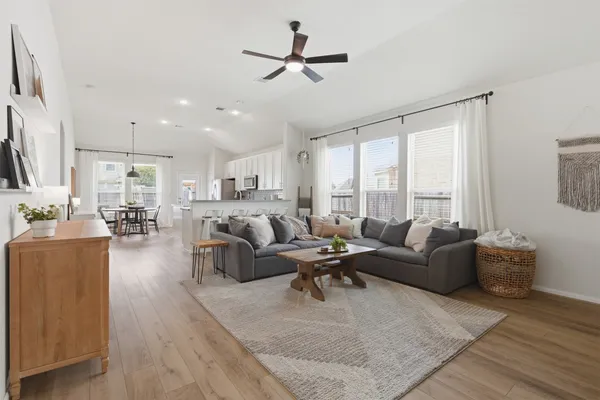 a living room with furniture kitchen view and a large window