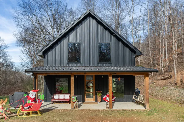 a view of a house with a big yard and large trees