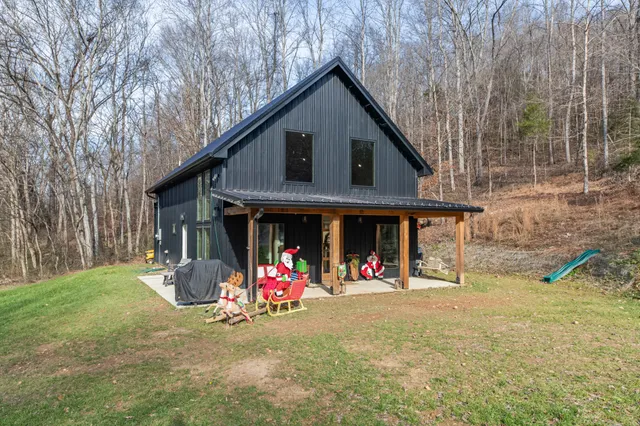 a open kitchen with stainless steel appliances granite countertop a refrigerator a stove top oven a dining table and chairs with wooden floor