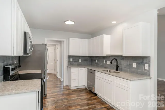 a kitchen with stainless steel appliances granite countertop a sink stove and cabinets