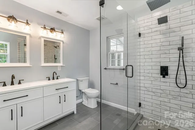 a bathroom with a double vanity sink toilet and shower