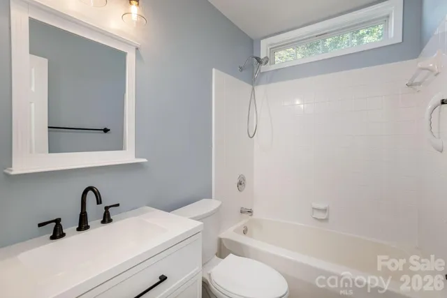 a bathroom with a sink toilet vanity and tub