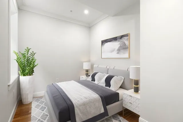 a bedroom with bed and a potted plant