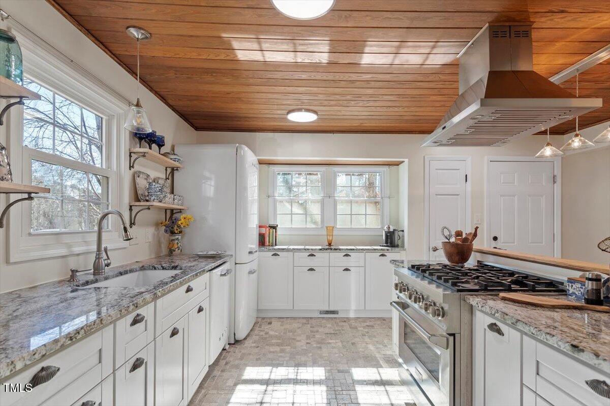 7120 Sandringham Drive Raleigh, NC 27613 - Photo 13 of 40 a kitchen with granite countertop a sink and a stove