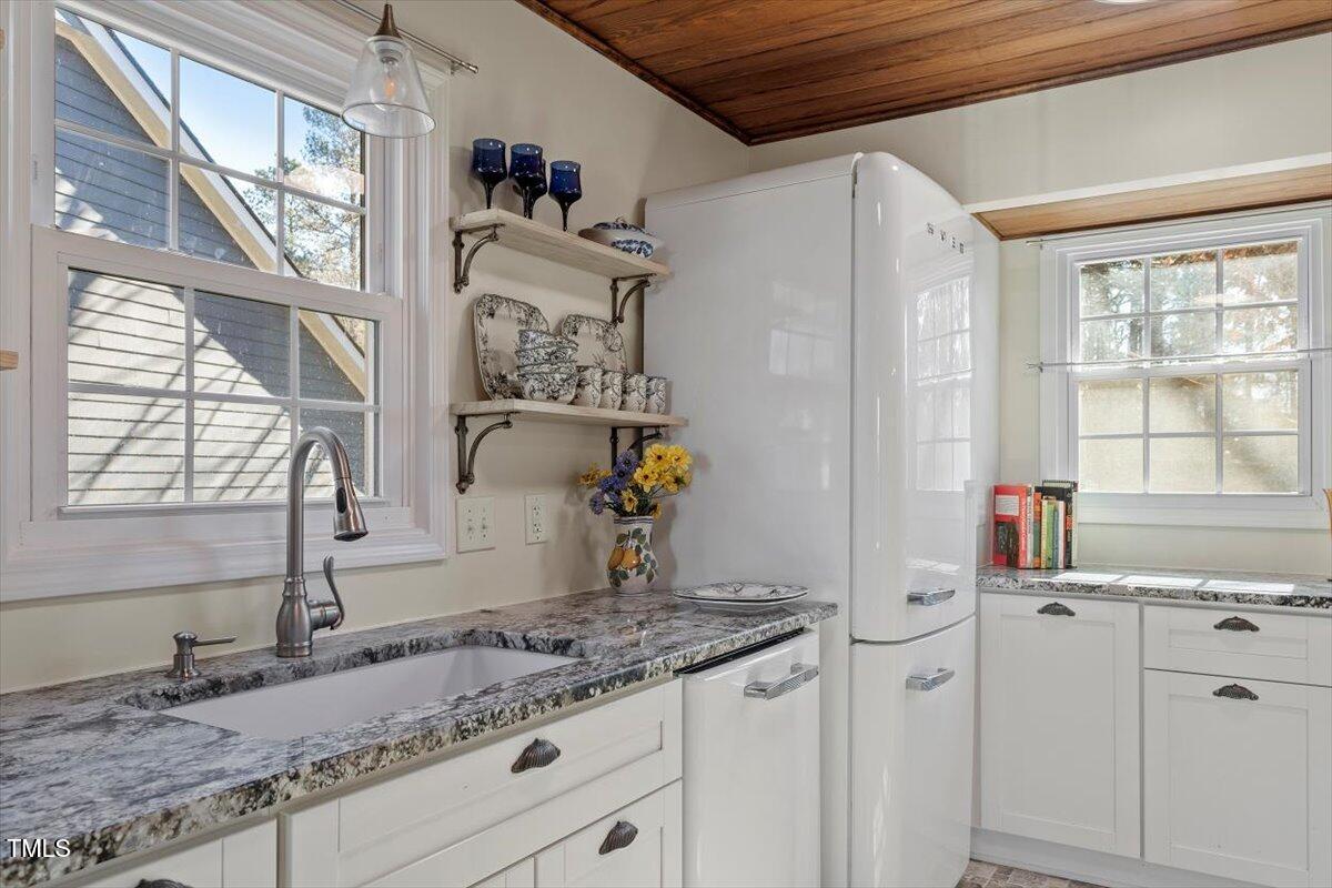 7120 Sandringham Drive Raleigh, NC 27613 - Photo 14 of 40 a view of a kitchen with granite countertop cabinets sink and a window