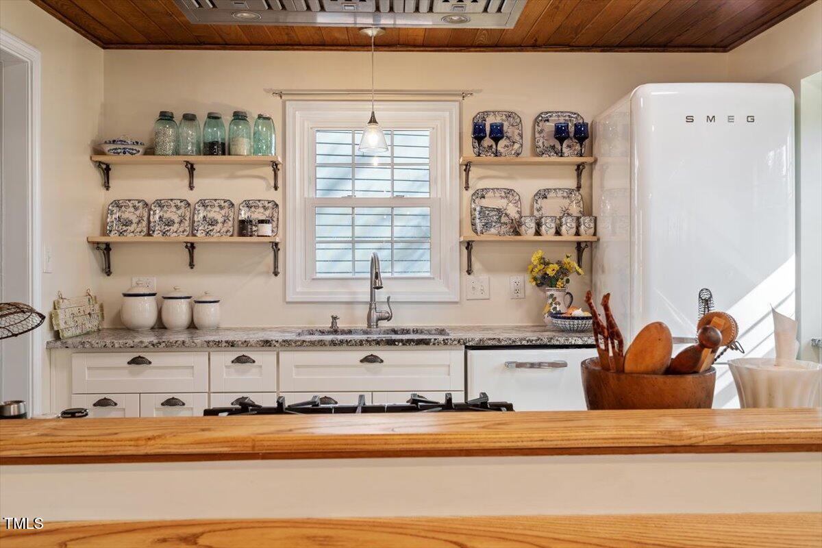 7120 Sandringham Drive Raleigh, NC 27613 - Photo 20 of 40 a kitchen with sink a refrigerator and cabinets