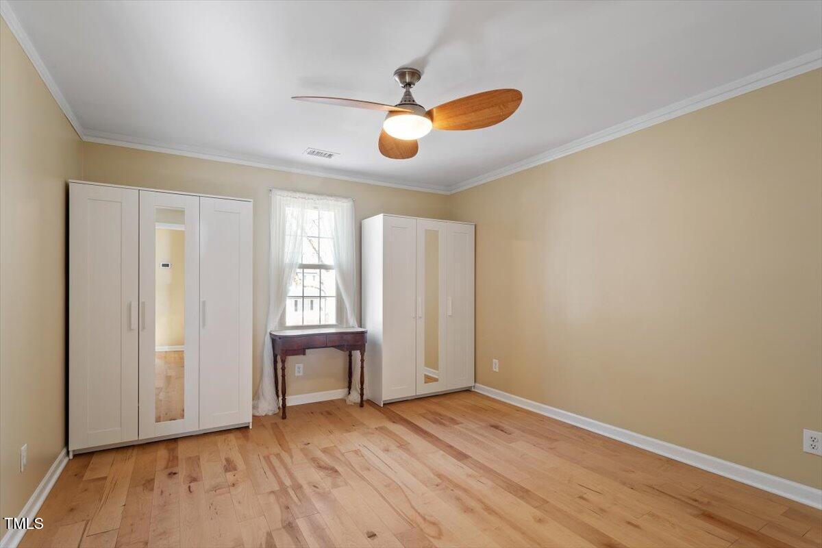 7120 Sandringham Drive Raleigh, NC 27613 - Photo 23 of 40 a view of an empty room with wooden floor and a window