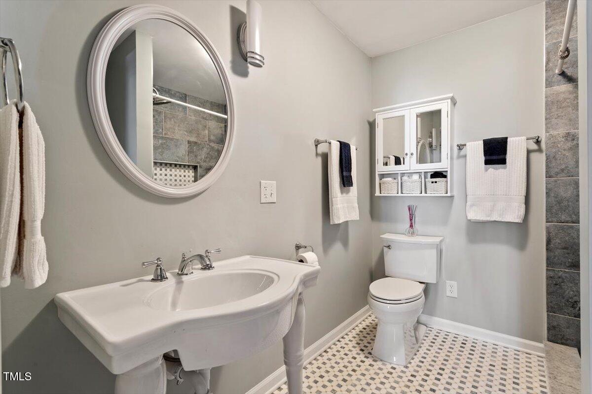 7120 Sandringham Drive Raleigh, NC 27613 - Photo 25 of 40 a bathroom with a sink a toilet and a mirror