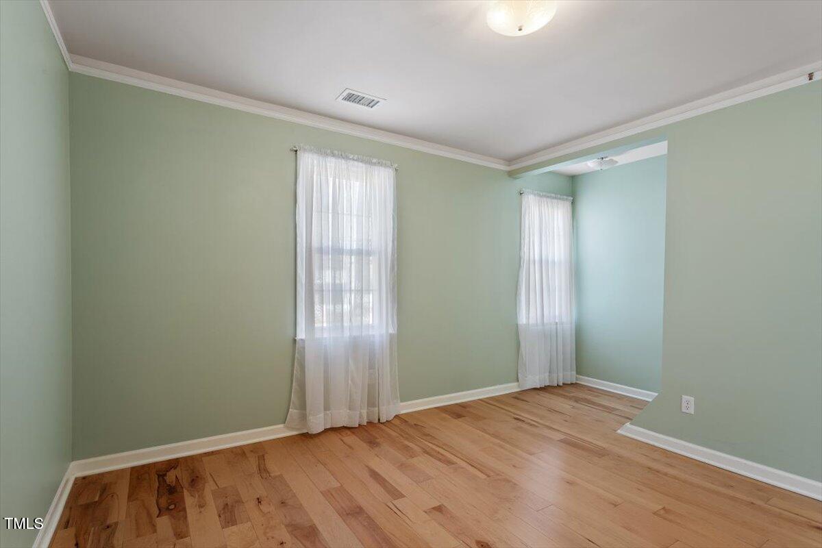 7120 Sandringham Drive Raleigh, NC 27613 - Photo 27 of 40 an empty room with wooden floor and windows