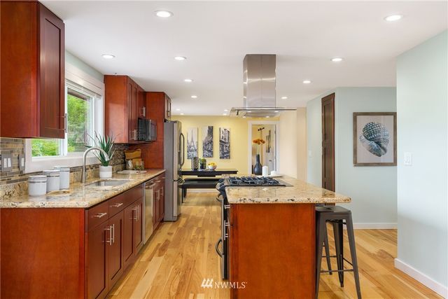 a kitchen with stainless steel appliances granite countertop sink stove and cabinets