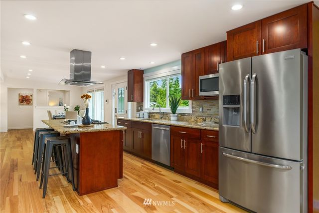 a kitchen with stainless steel appliances granite countertop a refrigerator a stove a sink dishwasher and a refrigerator