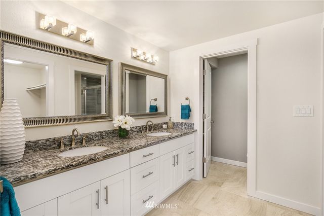 a bathroom with a granite countertop sink double and mirror