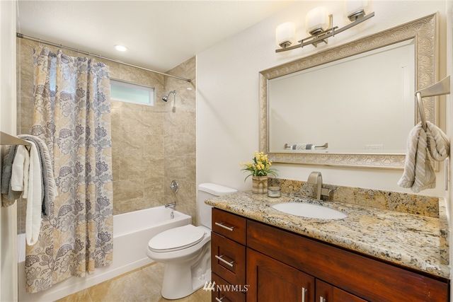 a bathroom with a granite countertop sink toilet and shower