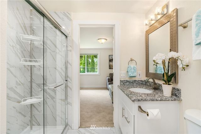 a bathroom with a granite countertop sink and a mirror