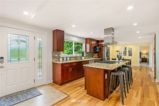 a kitchen with stainless steel appliances granite countertop a stove a sink and a refrigerator