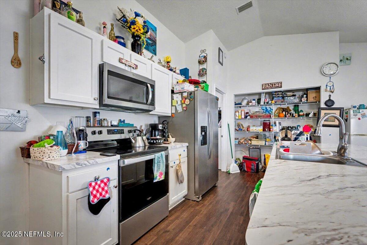 925 Scheidel Way St. Augustine, FL 32084 - Photo 6 of 10 a kitchen with a refrigerator and a sink
