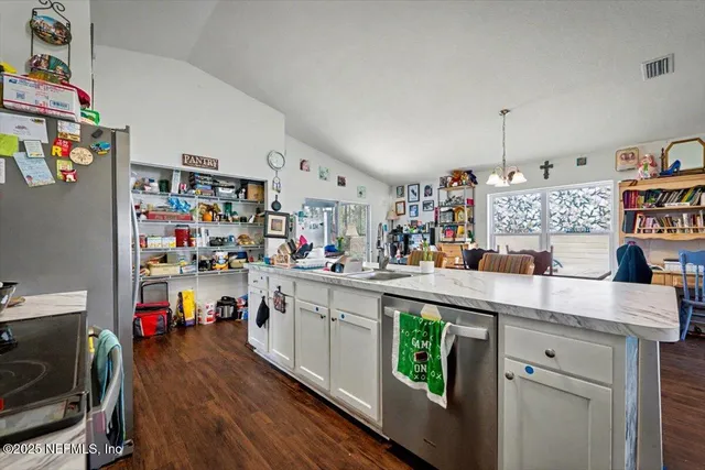 a kitchen with kitchen island a sink white cabinets and wooden floor