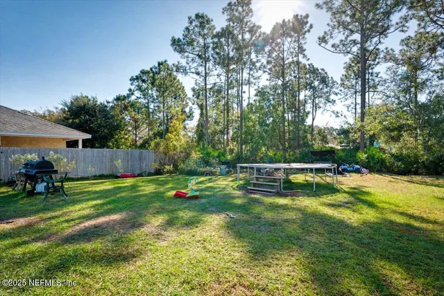 a view of a swimming pool with lawn chairs and a big yard