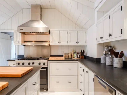 a kitchen with stainless steel appliances a sink a stove and cabinets