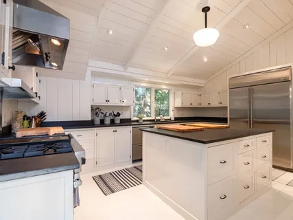 a kitchen with granite countertop a sink a counter space appliances and cabinets