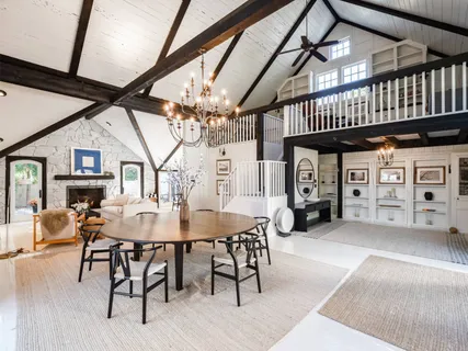 a view of a livingroom and a dining room with furniture wooden floor and a chandelier