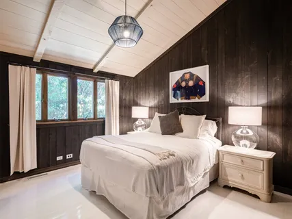 a bedroom with a bed and a lamp on dresser