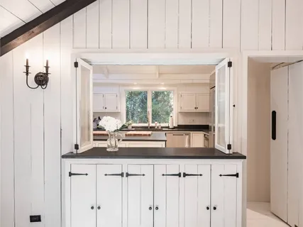 a kitchen with stainless steel appliances granite countertop white cabinets and window