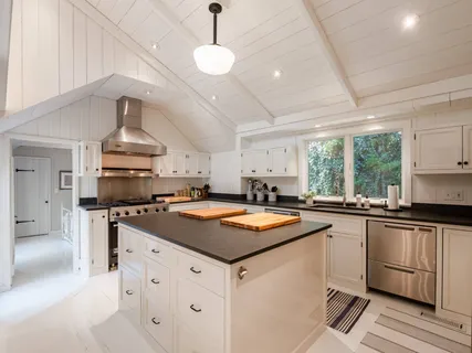 a kitchen with stainless steel appliances granite countertop a sink a stove and a refrigerator