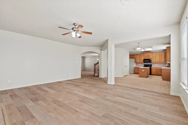 a view of a livingroom with a furniture wooden floor and a ceiling fan