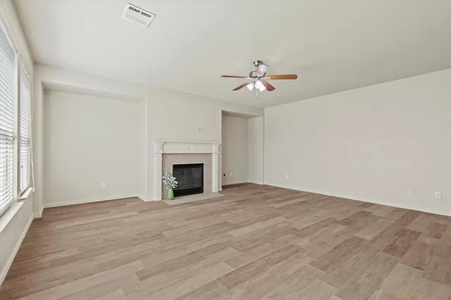 a view of an empty room with a fireplace and a window