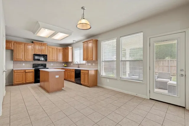 a kitchen with stainless steel appliances granite countertop a stove a sink dishwasher a refrigerator and white cabinets with wooden floor