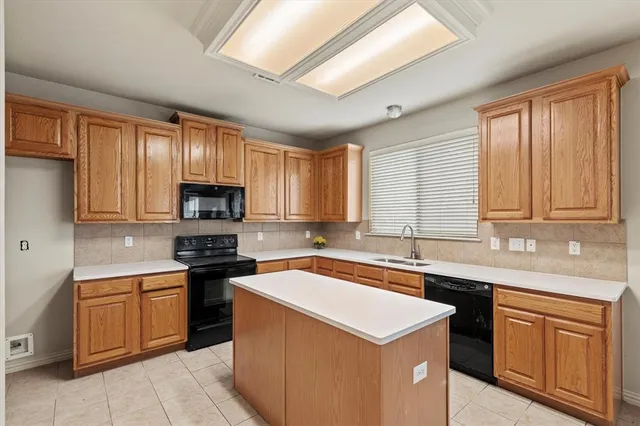 a kitchen with stainless steel appliances a sink stove refrigerator and cabinets