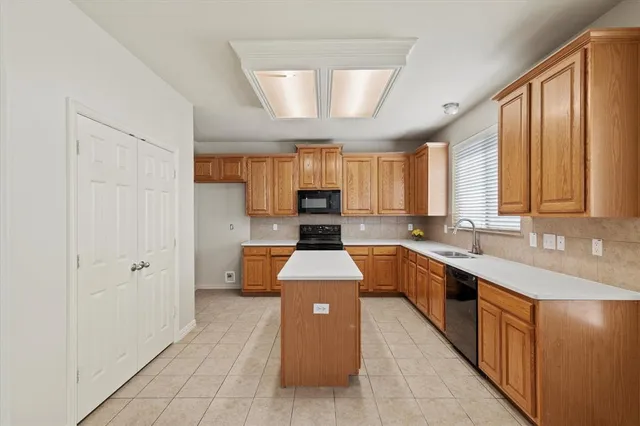 a large kitchen with stainless steel appliances granite countertop a stove a sink dishwasher and a refrigerator