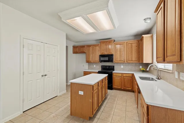 a kitchen with stainless steel appliances a sink dishwasher stove refrigerator and cabinets