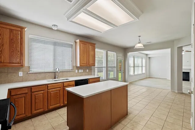 a large kitchen with kitchen island a sink a counter top space and appliances