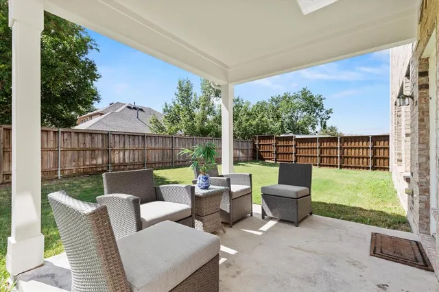 a view of a chair and tables in the back yard of the house